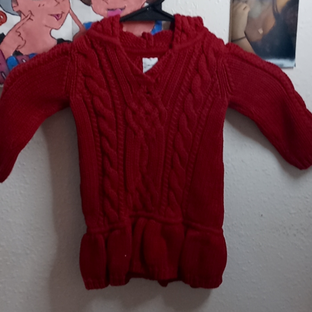 A red woven pull over sweater